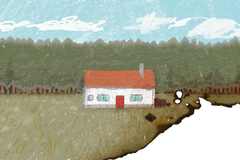 Postcard face depicting a white house in the meadow, with a forest in the background. The postcard is visibly burnt on the bottom right corner.
